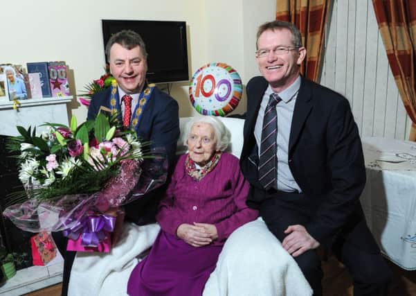 Elizabeth (Lizzie) Devlin, a resident at Cove Manor, Ardboe, pictured with Cookstown Council chairman Wilbert Buchanan and chief executive Adrian McCreesh, as they presented Lizzie with flowers when she celebrated her 100th birthday on New Year's Day.