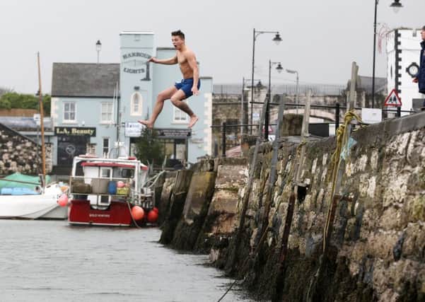 Freezin' for a reason! Late comer Stuart Gilmore makes a spectacular entrance as he jumps into the freezing wate rat the Spina Bifida Hydrocephalus New Year's Day charity swim at Carnlough Harbour. INBT 02-118JC