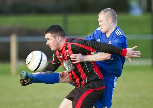 Rathfern's Phillip Gordon and Grove United Colin McClure battle for possession in Saturday's game at the Diamond. INLT 02-902-CON Photo: Philip McCloy