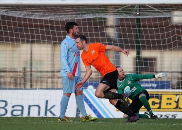 Ballymena United duo Brian McCaul and Stuart Addis look towards the referee's assistant as Glenavon's Ciaran Martyn wheels away after scoring the opening goal in Saturday's game at the Showgrounds.