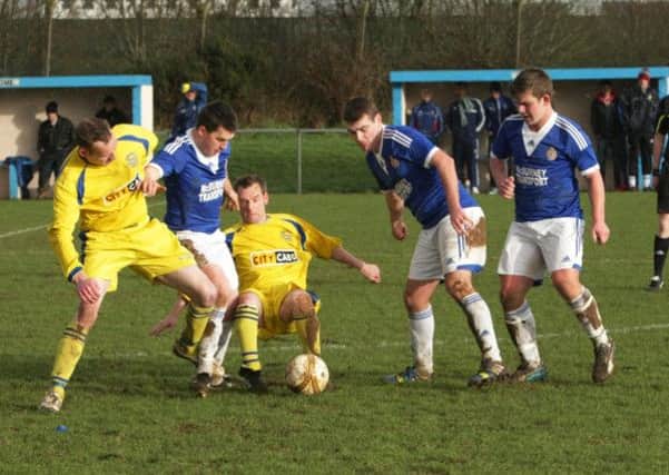 A midfield battle for possession during the early stages of the second half of Saturday's Irish Junior Cup clash at Wilton Park between Churchill and Raceview. INLS0115MC006