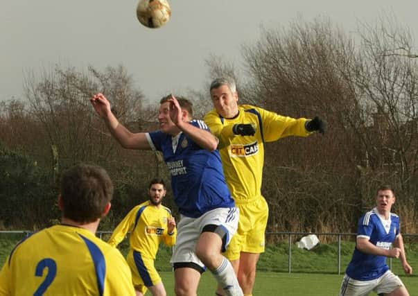 Churchill's Alan King wins this aerial battle during Saturday's Irish Junior Cup game at Wilton Park against Raceview. INLS0115MC002