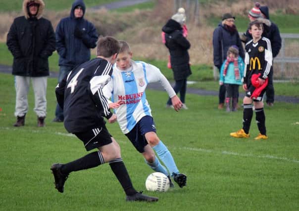 A Ballymena United under-13 player runs at the Carniny Youth defence. INBT 03-951H