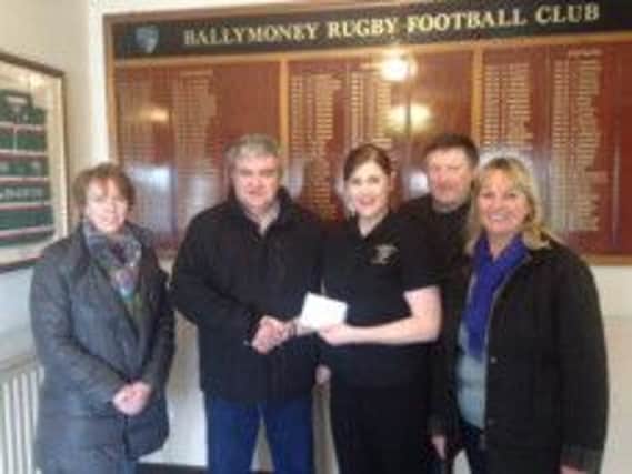 Ballymoney RFC Ladies captain Jen Murphy hands over a cheque to Mervyn Ferris and Fellow Cancer Research NI Local Committee Members.