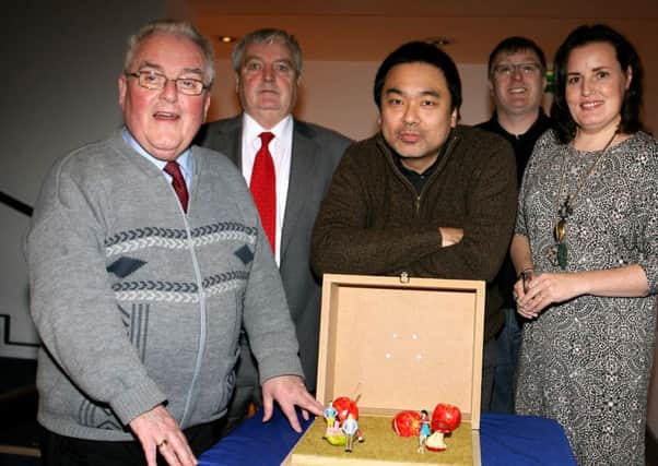 Artist Shiro Masuyama shows is art piece to PJ McAvoy (Chairman Dunclug Partnership), Colum Best (Project Manager Dunclug Partnership), David Gilliliand (Arts Council) and Roslyn Lowry (Arts and Events Development Officer). INBT03-216AC