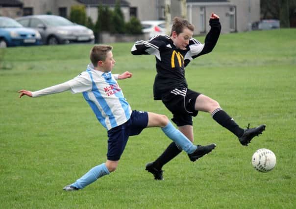 A Carniny Youth under-13 player gets to a loose ball ahead of his Ballymena United opponent. INBT 03-952H