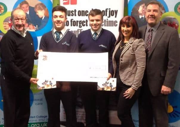 North Coast Integrated College principal, Paul Mullan, right and pupils Ross McDowell and Ryan Milligan handing over the cheque to Raymond Pollock for the Northern Ireland Children to Lapland Charity on behalf of  the College.