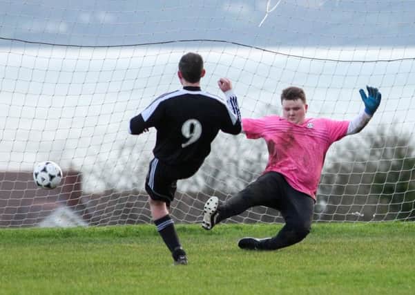 Andrew McIlrath slips it past the Carnlough keeper to put 1st Carrick Old Boys three up before half time. INLT 03-404-RM