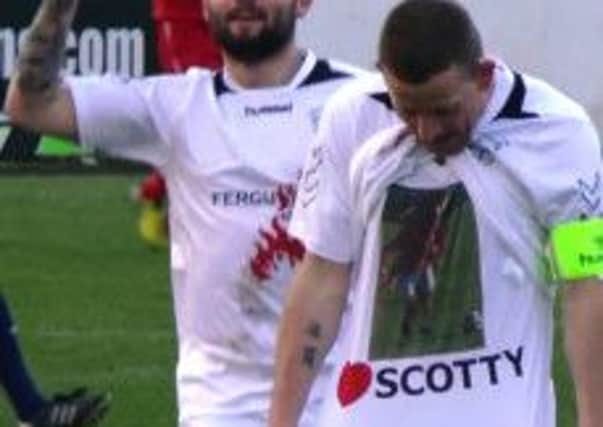 Larne skipper Paul Maguire reveals a Scott Irvine T-shirt after he scored his penalty against Ballyclare. Photo: Tommy Phillips