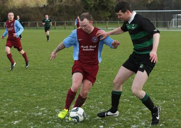 Newbuildings United midfielder Wesley Ferguson shields the ball from Dungiven's Kevin Boyle, during Saturday's league clash. INLS0215MC040