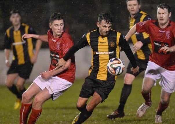 Carrick's Conor McCloskey gets away from Larne's Eoin Gillan. Photo: Presseye