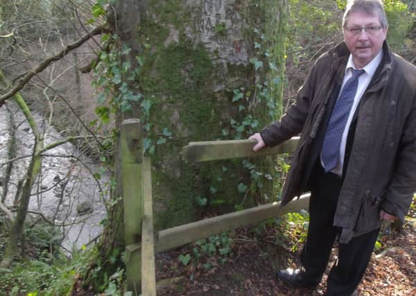 MP Sammy Wilson with a broken handrail at the National Trust's Gleno waterfall site. INLT-04-700-con