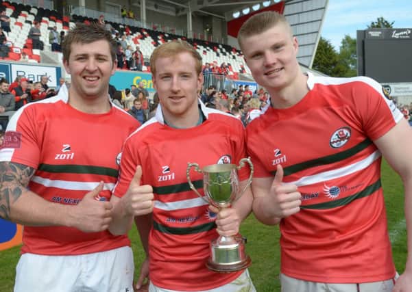Colin McKinty, Scott Montgomery and Jordan Burns celebrate Larne's 2014 Gordon West Cup success against Holywood at Ravenhill.