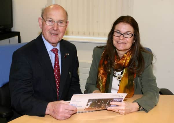Cllr. Roy Gillespie (Chair) and Karen Moore (Manager) of Ballymena PSCP look over the independent valuation report of the Ballymena PSCP action plan 2013-15, by Copius Consultanting. INBT05-208AC