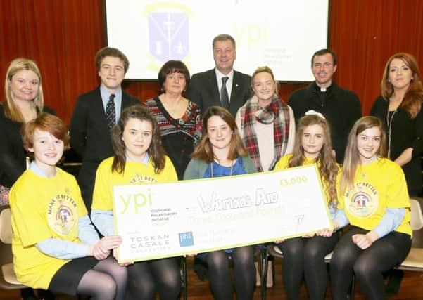 Charlotte Hodkinson (front centre) of the Youth and Philanthropy Initiative presents the first prize of £3000 to the winning Women's Aid team in the St Louis YPI charity competition. The team is L-R, Anna McClintock, Lauren Carey, Ellamay McIlhatton and Emily Murray while also included are, competition judges, back row, L-R, Una O'Kane (NRC), Ronan Hasson (student representative), Mrs Nuala McAteer (teacher),  Sean Rafferty (principal),  Ruth Owen (Women's Aid), Fr Darren Brennan (CC Ballymena), Maggie McWilliams (County Antrim Post).
