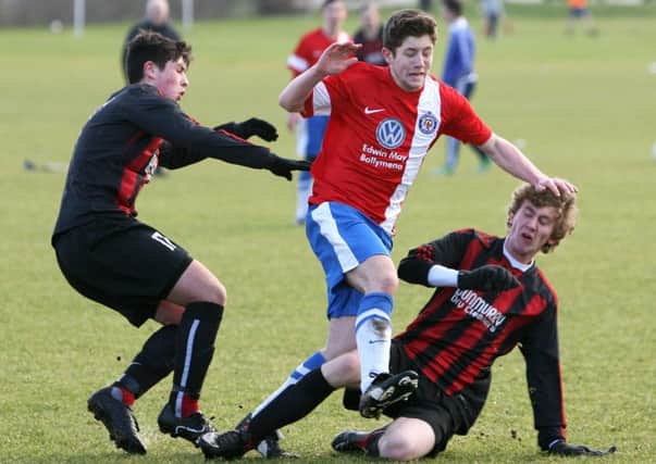 Southside's Dylan Hamill gets caught between two Dunmurry players during their match at Wakehurst. INBT05-224AC