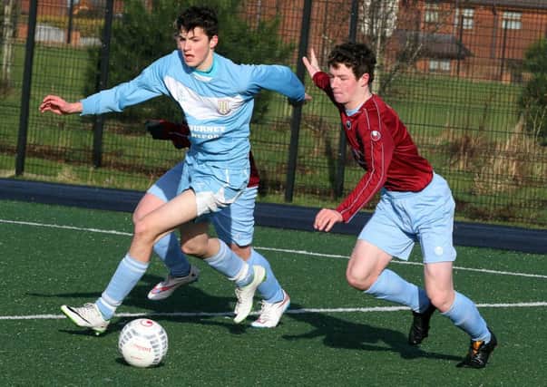 Institutes Todd Anderson, slips the ball between two Ballymena United playrs, during their under 16 game at Lisneal College. INLS0615-4393M.