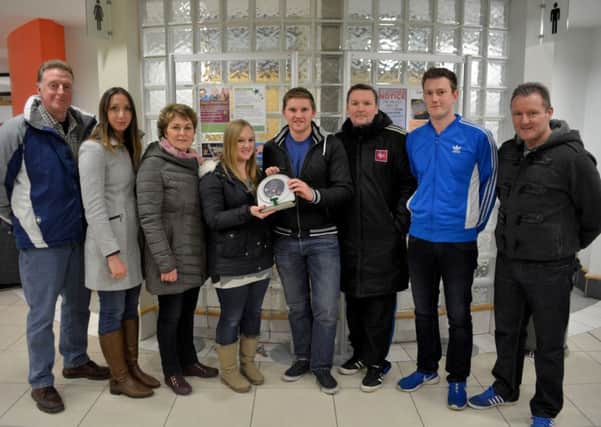 Jenny Bell from HeartSine hands over a defibrillator to Alan Wilson, second-team manager of Islandmagee FC. Also pictured are David Ross, Claire Connolly, Janet Ross, Stephen Donald (first-team manager), John Brennan (second-team player) and Noel Dean (second-team player). INCT 04-142-GR