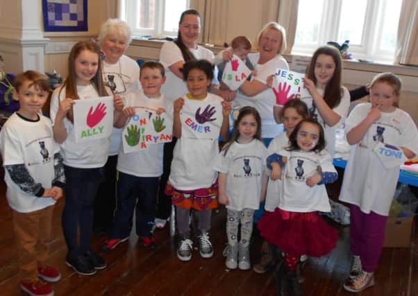 Members of Kinship Care and some of the children who benefit from the charity's work, celebrate the funding boost.