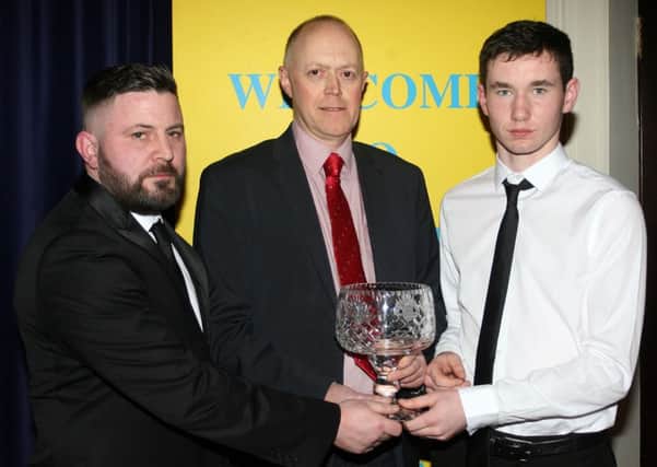 Sean O'Brian (coach) and Ryan McGarry (captain) of All Saints GAC U-14 receive the Team of the Year award from Raymond Ruck, of sponsors Michelin. INBT06-227AC