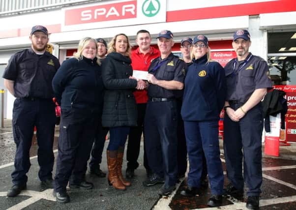 Emma Irwin presents a donation of £3000 on behalf of Hendersons (Broughshane Spar) to Eamon Worthington, unit commander of Portglenone Community Rescue Service. Hendersons donated the same amount of money recently raised by Emma and friends in the village, in memory of the late Paul Houston. Included are Jordan Sneddan  (Spar) and members of the Community Rescue. INBT06-249AC