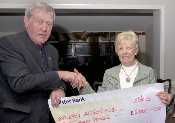 Gordon McIlwaine, president of Northern Ireland Landrover Club, presents a cheque to Morina Clark of Epilepsy Action NI at the club's AGM in Knockagh Lodge.  Epilepsy Action were the group's nominated charity for 2014.  INCT 06-732-CON
