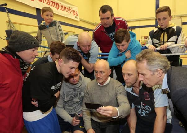 Barry  McGuigan shows club members a video on his phone of Carl Frampton sparring in preparation for his world title defence. INBT 07-184CS