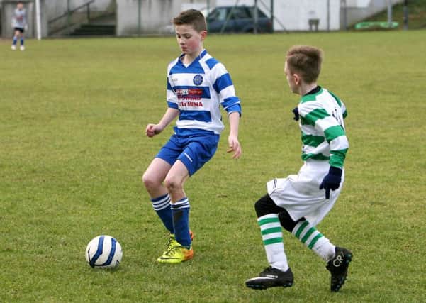 Northend U-12 player Calum Kilgore takes control of the ball before his St. Pats opponent can tackle him. INBT07-250AC