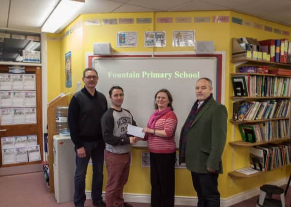 Fountain  Primary headmistress, Cathy Arthur, receiving a cheque from the William King Memorial Flute Band.