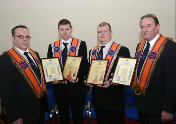 Harry Cross, left, Deputy Master, and Robin Logan, right, Worshipful Master, L.O.L. 1912, presenting Grand Orange Lodge of Ireland and Grand Arch Purple Chapter initiation certificates to Aaron Theobald and Chris Walker, at a ceremony held by City of Londonderry District No.4 in the Diocesan Offices at London Street. INLS0715-113KM