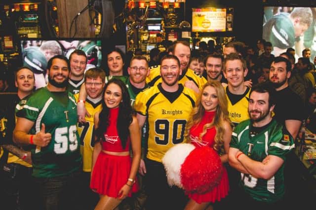Pictured at the Belfast Trojans Super Bowl party at Madisons, Belfast, with Bud cheerleaders Rebekah Shirley and Meagan Green, are players from the Belfast Trojans and the Carrickfergus Knights where competitive rivalry was set aside for the social event. INCT 07-754-CON