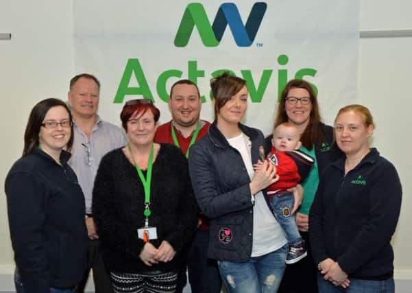 Head of site at Actavis Millbrook, Jim McIlroy (2nd left) is pictured with members of the social responsibility team, Margo Cunning, Janice Purvis, Neil Clarke, Joanne McNeill and Helen Spoor who donated £1000 to Kerry Magee to help purchase a helmet for her 7 month old son, Wyatt. INLT 07-029-PSB