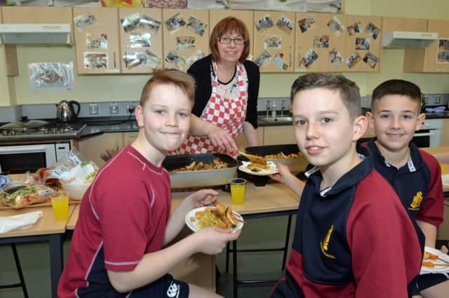 Mrs McVeigh serves food to Robert, Taylor and Alex at the Chinese taster day at Downshire School. INCT 08-003-PSB