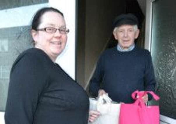 Davys Street Residents' Association committee member Elaine Doey hands over a pair of 'Keep Warm' packs to local resident Mr Mercer.  INCT 08-728-CON
