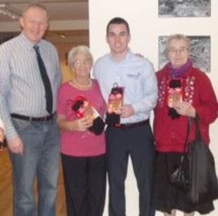 Pictured left, Ron McMurray with Doreen Scroggie, and Martha Rainey, Harryville Partnership receiving their winter warmers from Gary Crossan of Power NI.