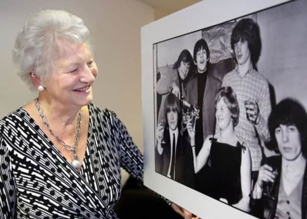 Dame Mary Peters looks at a photo of herself sharing a bottle of Champaign with the Rolling Stones, taken when she won the BBC Sports Personality of the Year award following her Olympic gold medal. US1506-552cd  Picture: Cliff Donaldson