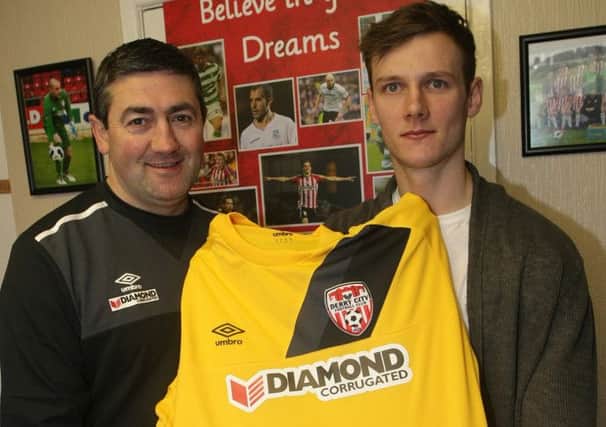 Derry City's latest signing Seanan Clucas pictured with manager Peter Hutton and the club's new away jersey.