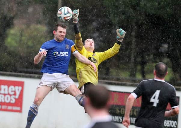 Wakehurst goalkeeper Marc Maybin clears his lines under pressure from Limavadys Hugh Carlin.