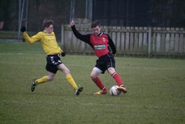 Banbridge Town Juniors left-back William Irwin turns a Midway player.