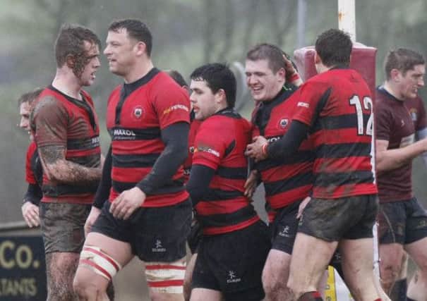 Carrickfergus' M Smylie gets the congratulations from his colleagues after scoring a try