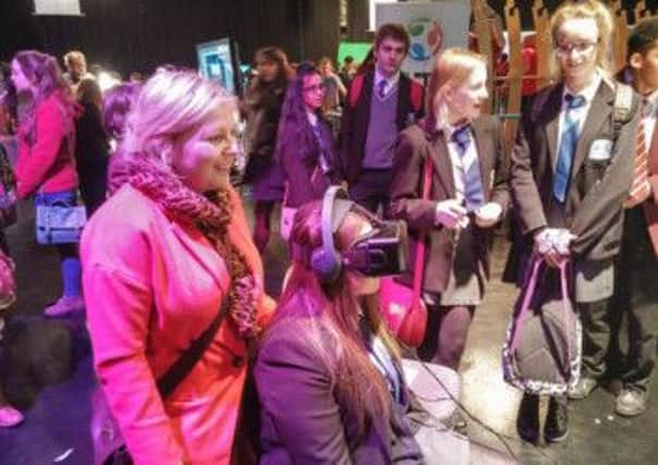 Mrs Evans, Rebecca Wilson and Jordan Lennon look on as Alicia Whiteside experiences a virtual world using the Oculus Rift.  INCT 10-721-CON