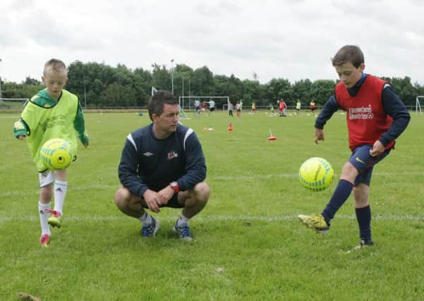 Maiden City coach Ryan Semple coaching ball control to under-12 s Aaron Moore and Jack Harkin at Wilton Park.