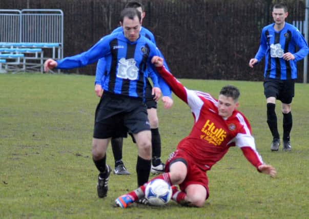 James Price of Carniny Amateurs closing down his Aquinas opponent at a wet Showgrounds last Saturday