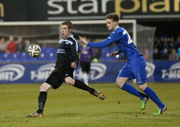 Ballymena United striker Darren Boyce gets his pass away from Dungannon's Douglas Wilson during Friday night's game at Stangmore Park. Picture: Press Eye.