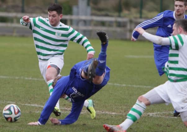 A Ballymoney player takes a tumble following a challenge from his Lurgan opponent on Saturday.