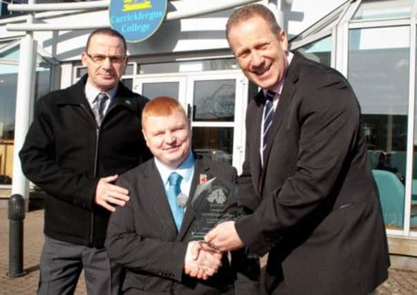 Carrickfergus College principal Hedley Webb is presented with a crystal plaque by Andy Allen.  INCT 10-720-CON