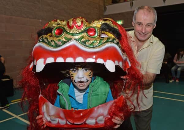Jack Erdis dressed as a dragon with Seamas Olabhradha from Artsekta at the Celebration of Cultures day in Larne Leisure Centre. INLT 10-023-PSB