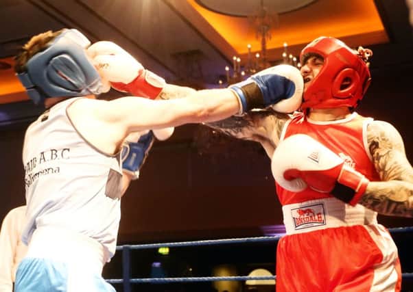 David Moore (blue) and Paul McKee (red) both take a punch to the face during their bout at the White Collar Fight Night raising money for the Northern Ireland Hospice. INBT11-267AC
