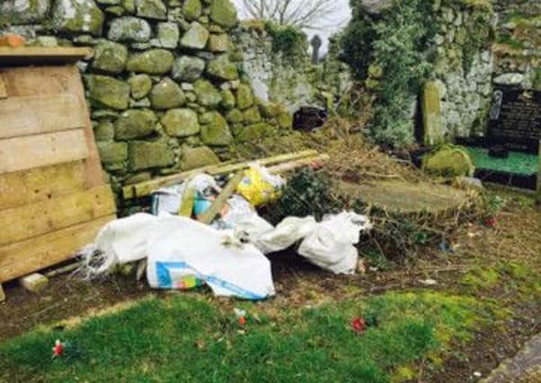 Equipment and rubbish strewn along the graveyard path at Ardboes High Cross