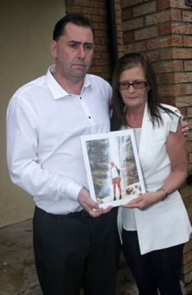 Dennis and Sharon Orsi, pictured yesterday afternoon with a photograph of their late daughter Lisa, who fell critically ill during a holiday in Indonesia on February 20 and never regained consciousness. DER1015MC116